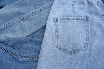 Lots of jeans pants in a stack. Denim background.