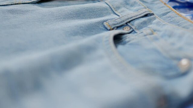 Background of blue color from clothes of jeans, Jeans close-up of blue color lies, fabric of jeans close-up pocket of trousers of the button the lock zipper, Background from clothes of jeans blue
