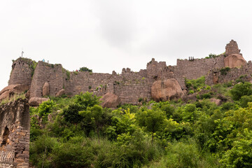 Fototapeta na wymiar Low angle view of the stone fortification walls of the ancient Golconda Fort.