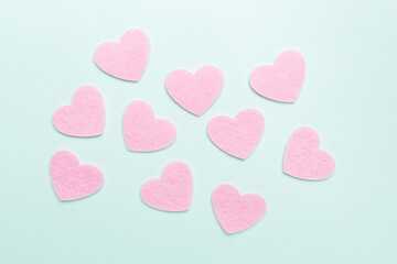 Felt hearts on color background, top view