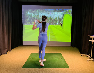 Fototapeta na wymiar Female golfer makes golf swing indoors concept