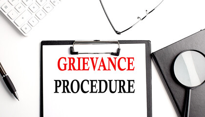 GRIEVANCE PROCEDURE text written on paper clipboard with office tools