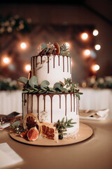 beautiful wedding cake with white roses in the background on a blurred of a restaurant