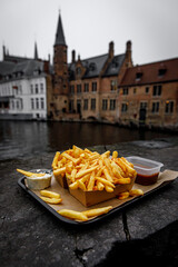 Fototapeta premium French fries on the background of the canal in Bruges, Belgium