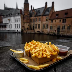 Poster Eating traditional street food - the Belgian Fries outdoors in Europe's old town. © 9parusnikov