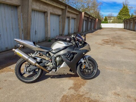 Silver Yamaha R1 in a garage yard on a sunny day