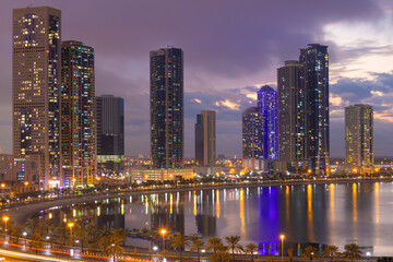 Fototapeta na wymiar Sharjah city in uae cityscape at sunset in a cloudy day with lake view