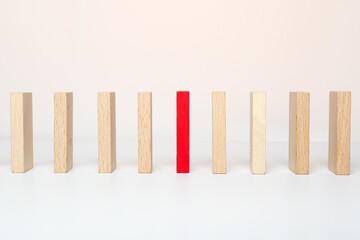 . One red wooden block between the wooden block on white background