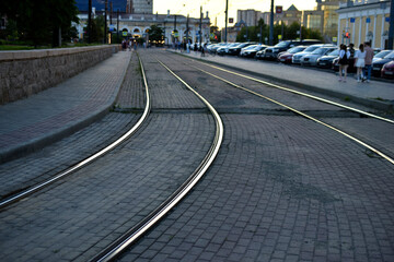 The iron rails of the city tram in the evening. Evening city. Urban transport and the road.