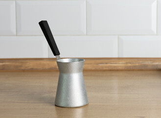 A metal coffee pot on a light kitchen background.