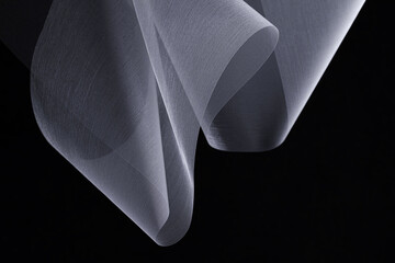 Futuristic abstract background. Translucent unusual shapes. Organza on a dark background. White fabric texture.