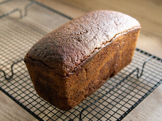 Freshly baked rye bread cools down on a metal grate. soft daylight. Horizontal. Close up, copy space