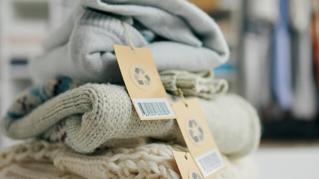 Stack of clothes with tags and recycle sign, recycle sign on clothes, clothes sweater pants reuse recycling and sorting clothes, shop with recycle signs, save our planet
