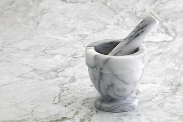 Mortar and pestle on marble kitchen surface - obrazy, fototapety, plakaty