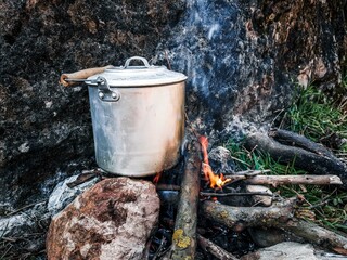 Cooking in a pot over the campfire. The concept of adventure, travel, tourism and camping