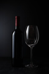 Empty Wine glass and Bottle on dark background.