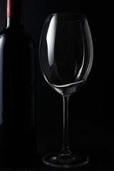 Empty Wine glass and Bottle on dark background.