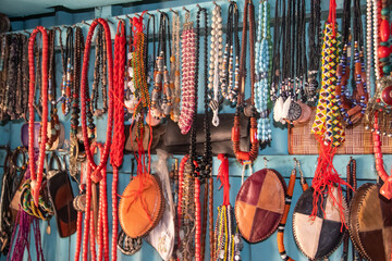 African local souvenir shop with colorful necklaces, leader bags, traditionally handmade and exposed on shelves of small market