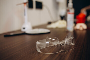 Dental medical glasses with binocular lenses, in dentistry clinic. Dentist glasses or dental optic on a real medical laboratory. Modern technology equipment in background of surgery room.