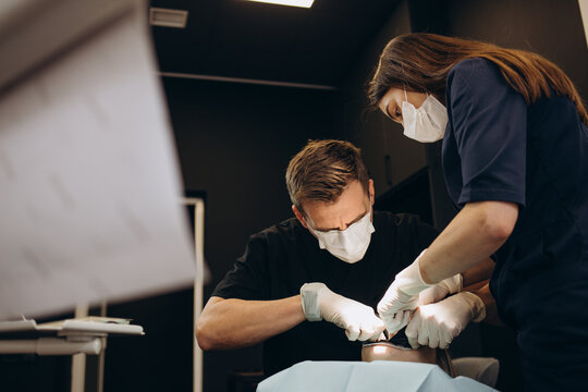 Painkiller anesthesia injection. Dentist examining a patient's teeth in modern dentistry office. Closeup cropped picture with copyspace. Doctor in disposable medical facial mask.