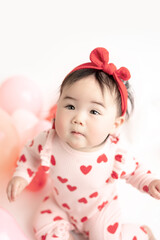 Obraz na płótnie Canvas baby with valentine's heart shaped balloons