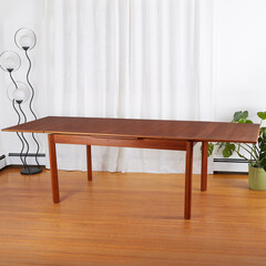 Mid-century modern dining room table. Viewed in a room with a retro-futurist floor lamp and houseplants.