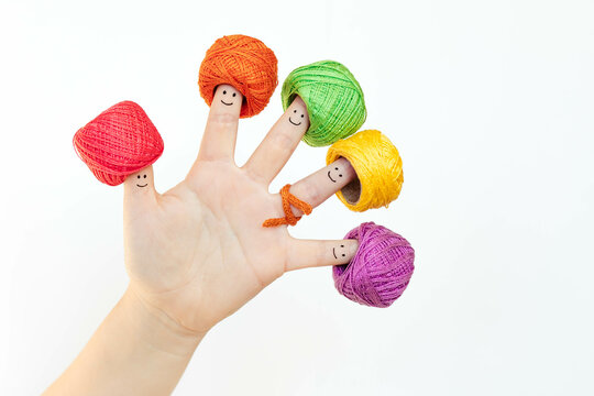 Fingers in color hats with drawing of funny smiling faces.