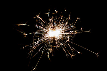 Burning sparkler isolated on black background. Fireworks theme. Light effect and texture.