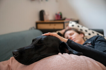 Young woman and her dog resting on a couch