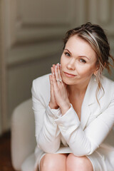 an attractive and gentle woman in a white suit. 