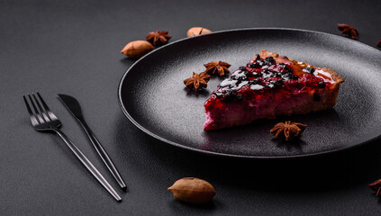 Delicious fresh pie with raspberries and other berries and cheese on a dark plate