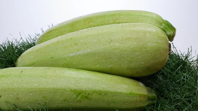 several zucchini on a background of grass rotate on a spinning background