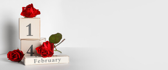 Cube calendar with date of Valentine's Day and red rose flowers on light background with space for text