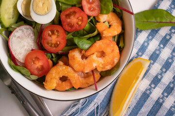 Salad with shrimps, tomatoes in a plate