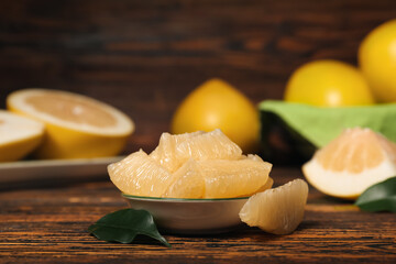 Plate with slices of tasty pomelo fruit on table, closeup