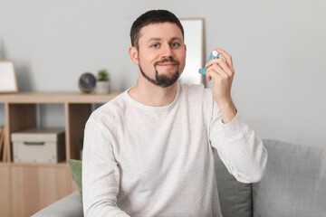 Portrait of man with inhaler at home