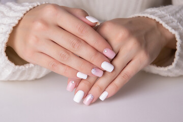 Obraz na płótnie Canvas Beautiful female hands with pink and silver manicure nails on white background