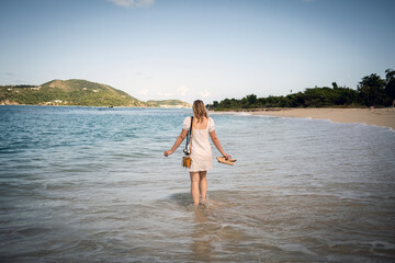 Carefree happy woman walks on beach