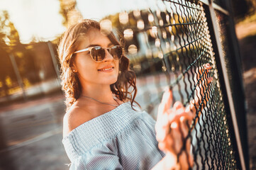 woman in sunglasses looking thru fence