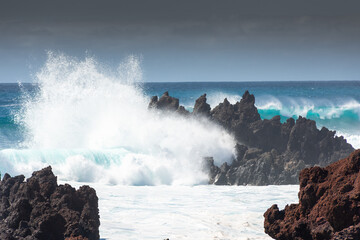 Fototapeta na wymiar Powerful waves against the sea stacks of Lanzarote island, Atlantic Ocean, Canary Islands in Spain