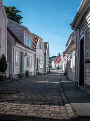 Fototapeta na wymiar Old town Gamle Stavanger with white timber houses in Norway, during sunshine and blue sky