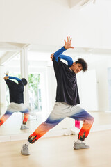 Vertical image of biracial male hip hop dancer practicing at dance studio with copy space