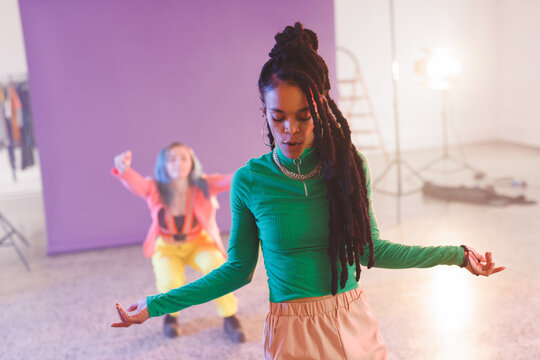 Image of group of two happy diverse female hip hop dancers in studio