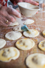 Close up of human hand preparing puff pastry damplings