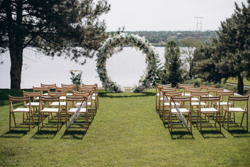 wedding ceremony arch with empty chairs and flowers. beautiful romantic decoration