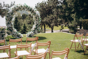 wedding ceremony arch with empty chairs and flowers. beautiful romantic decoration