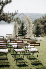 wedding ceremony arch with empty chairs and flowers. beautiful romantic decoration