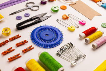 Image of sewing materials with scissors, buttons and threads on cream background