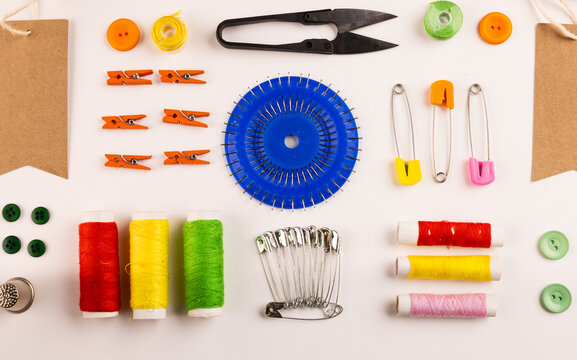 Image of sewing materials with scissors, buttons and threads on cream background
