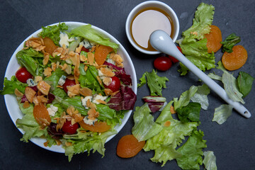 Salad on white plate, on black stone table